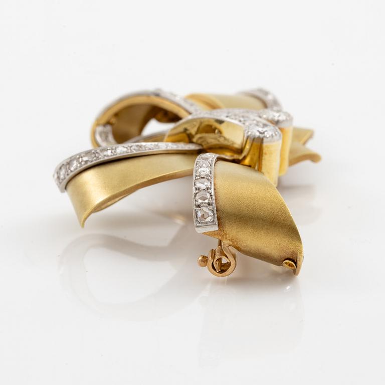 Bow brooch in 18K gold and platinum set with round brilliant, eight-cut, and rose-cut diamonds.