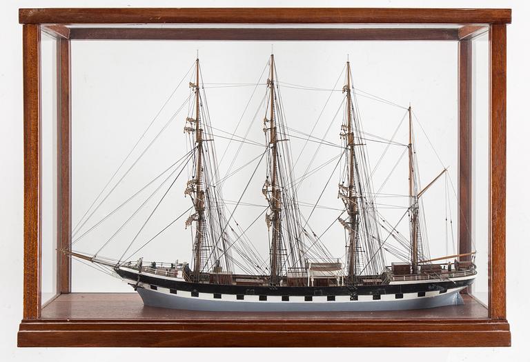 A model of a sailing ship with four masts in a glass and mahogany box by Gustav Sixten Wiman, 20th century.