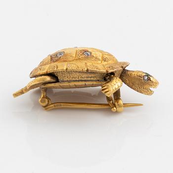 A brooch in the shape of a turtle.