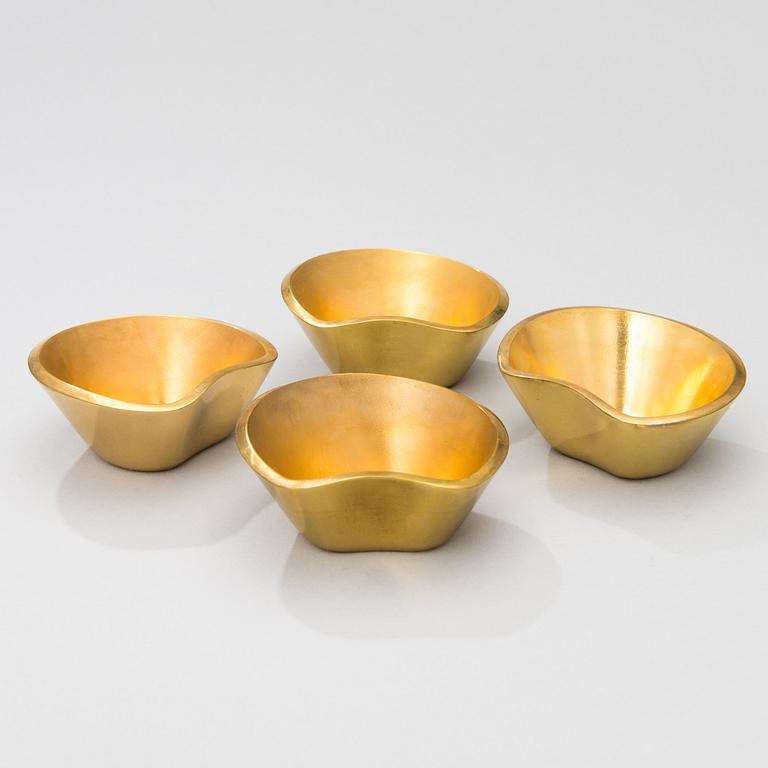 A set of four brass ashtrays, designed in 1947.