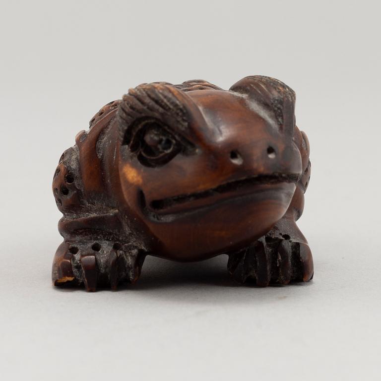 A carved wooden netsuke in the shape of a frog, 20th century.