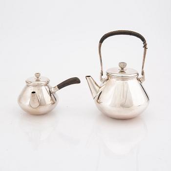 A set of two Japanese early 20th century sterling silver tea pots weight 474 grams.