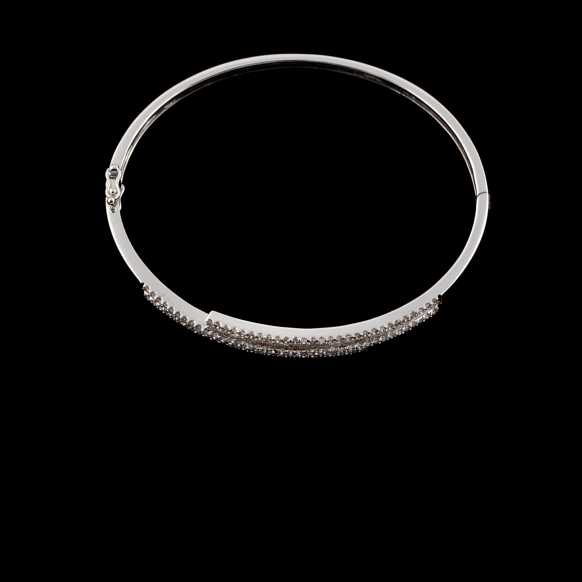 ARMRING, 18k vitguld med briljant och baguettslipade diamanter, 1.19 ct. Vikt 8,8 g.