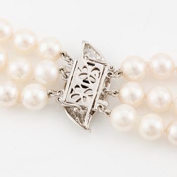 Necklace, pearls, three strands, clasp in 14K white gold with small diamonds.