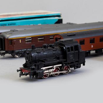 A set of Märklin electric trains, wagons,  rails, and a bridge.