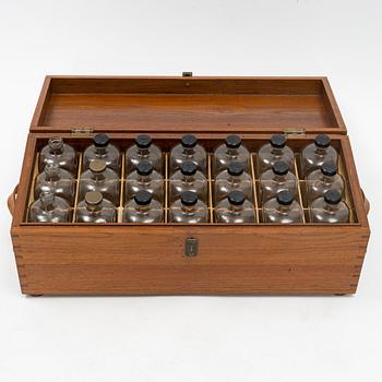 A teak box with 21 glass blottles, early 20th Century.