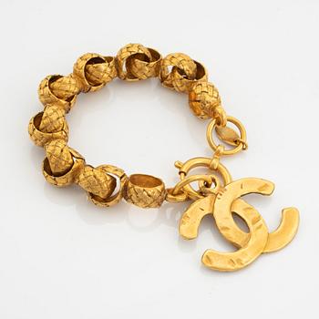 Chanel, a gold tone bracelet.