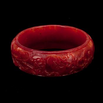 ARMBAND, rödfärgad jadeit, 1900-talets senare hälft.