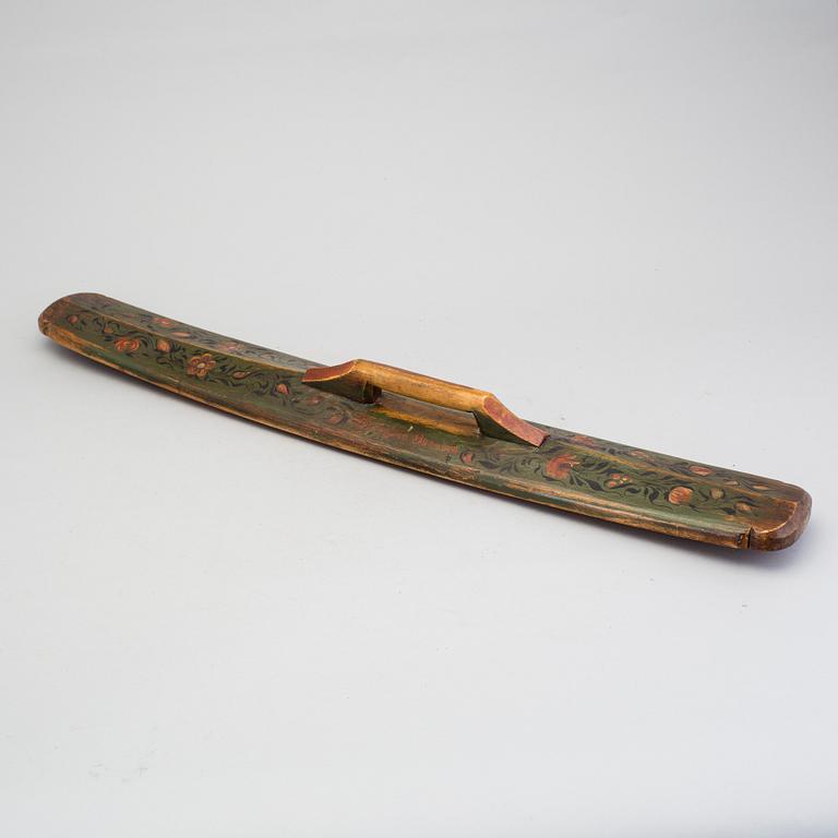 A painted folk art mangling board and sickel dated 1872 and 1847.