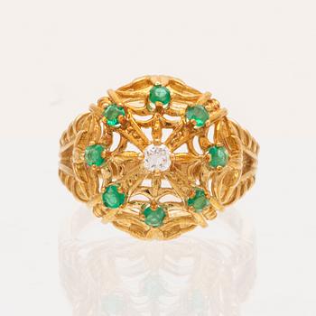 An 18K gold ring set with a round brilliant cut diamond and round single cut emeralds by Franklin Mint 1980.