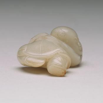 A nephrite figure of a reclining boy holding a lingzhi fungus, 20th Century.