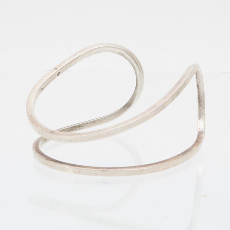 Efva Attling, stelt armband "Loop cuff" samt örhängen av silver.