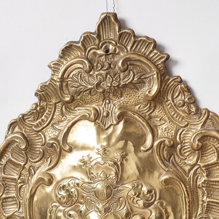 A pair of North European Rococo two-branch repoussé brass reflector plates, mid 18th century.