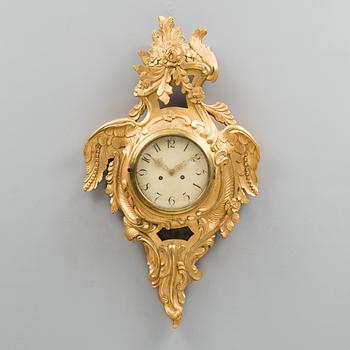 A Rococo-style pendulum wall clock from the 20th century.