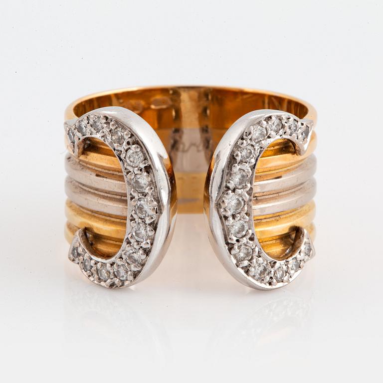 A Cartier "Double C" ring in 18K tri color gold set with round brilliant-cut diamonds.