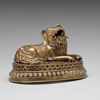 A copper alloy figure of a reclining buddhist lion, presumably 18th Century.