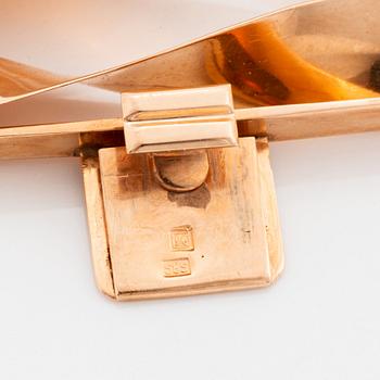 A 14K gold bracelet and a brooch.