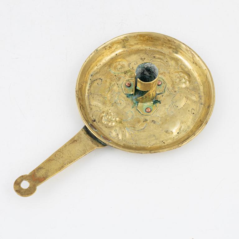 A repousse brass baroque candlestick, circa 1700.