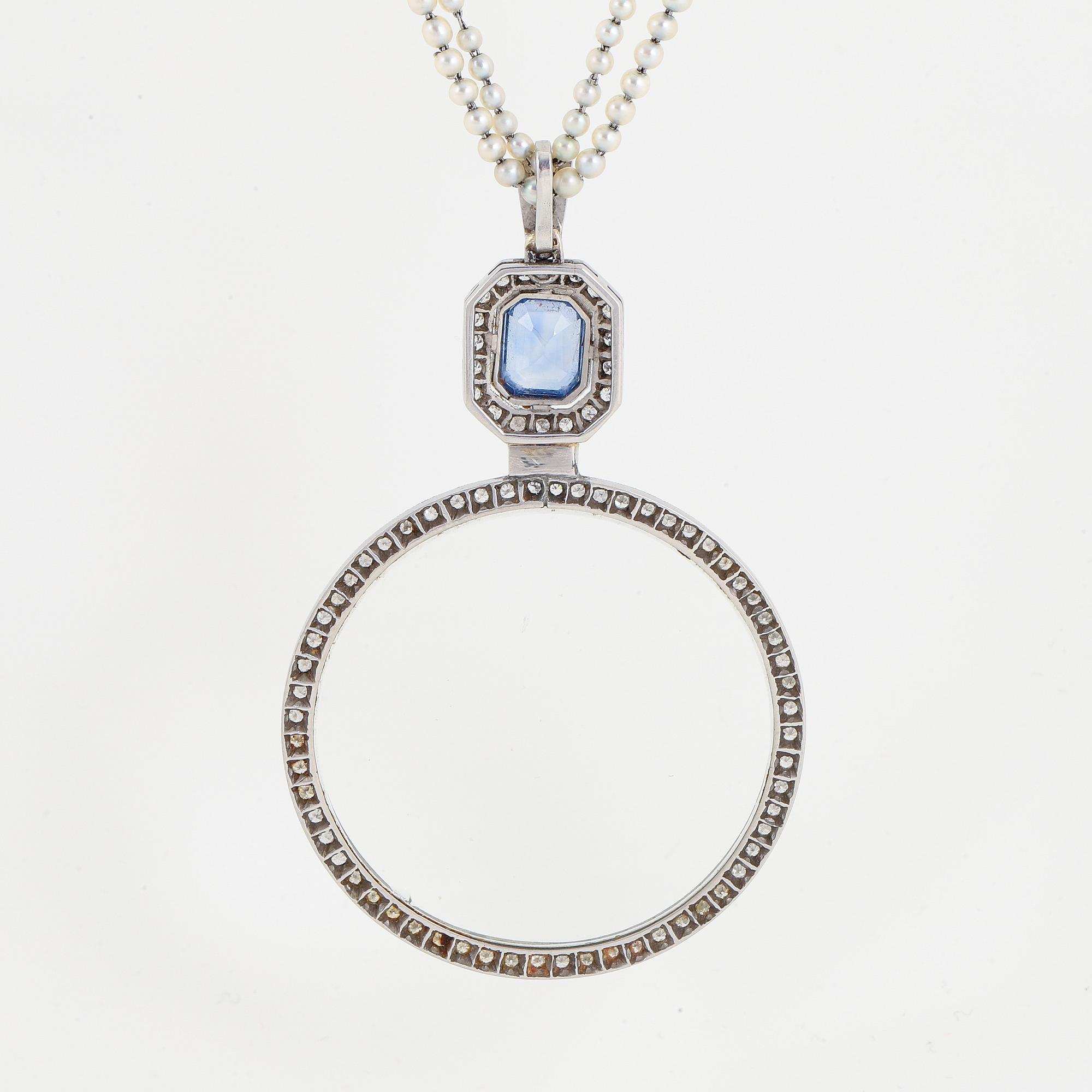 A platinum lorgnette set with a faceted sapphire and rose-cut diamonds.