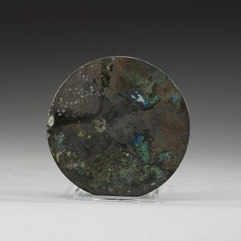 A bronze mirror decorated with stylized dragons and tigers, Eastern Han dynasty (25-220).