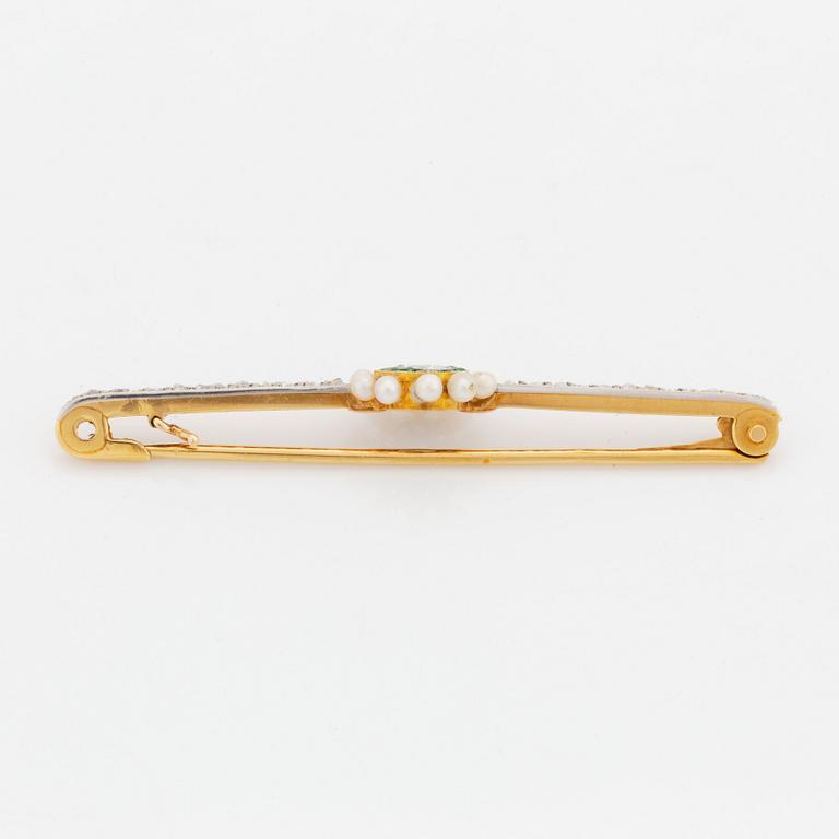 A gold and platinum brooch set with an old-cut diamond, pearls, emeralds and rose-cut diamonds.