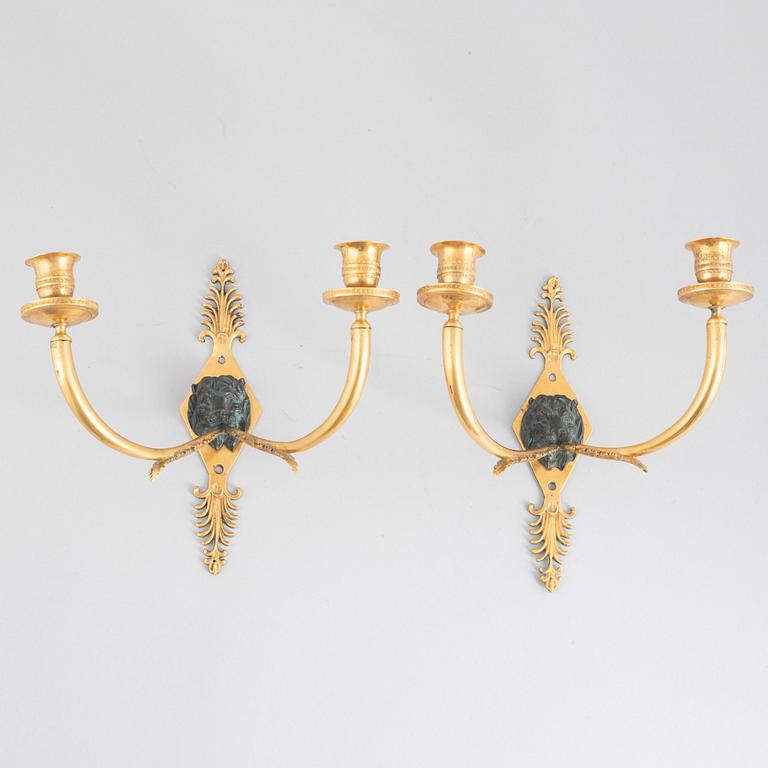 A pair of Empire-style two-branch patinated and gilt bronze appliques, 20th century incorporating older elements.