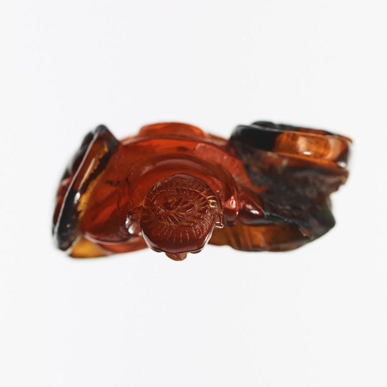 An amber figurine of a sitting man with baskets, Qing dynasty (1644-1912).