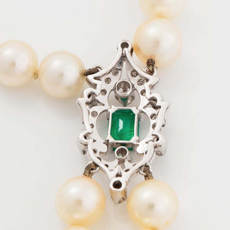 A two strand cultured pearl necklace clasp in 18K white gold set with a faceted emerald.