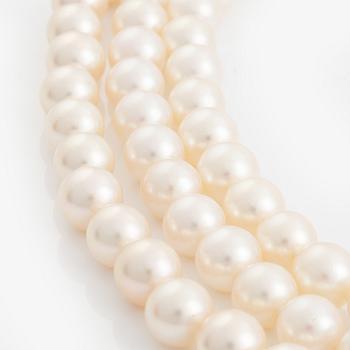 A three strand cultured pearl necklace with a platinum clasp set with eight- and baguette-cut diamonds.