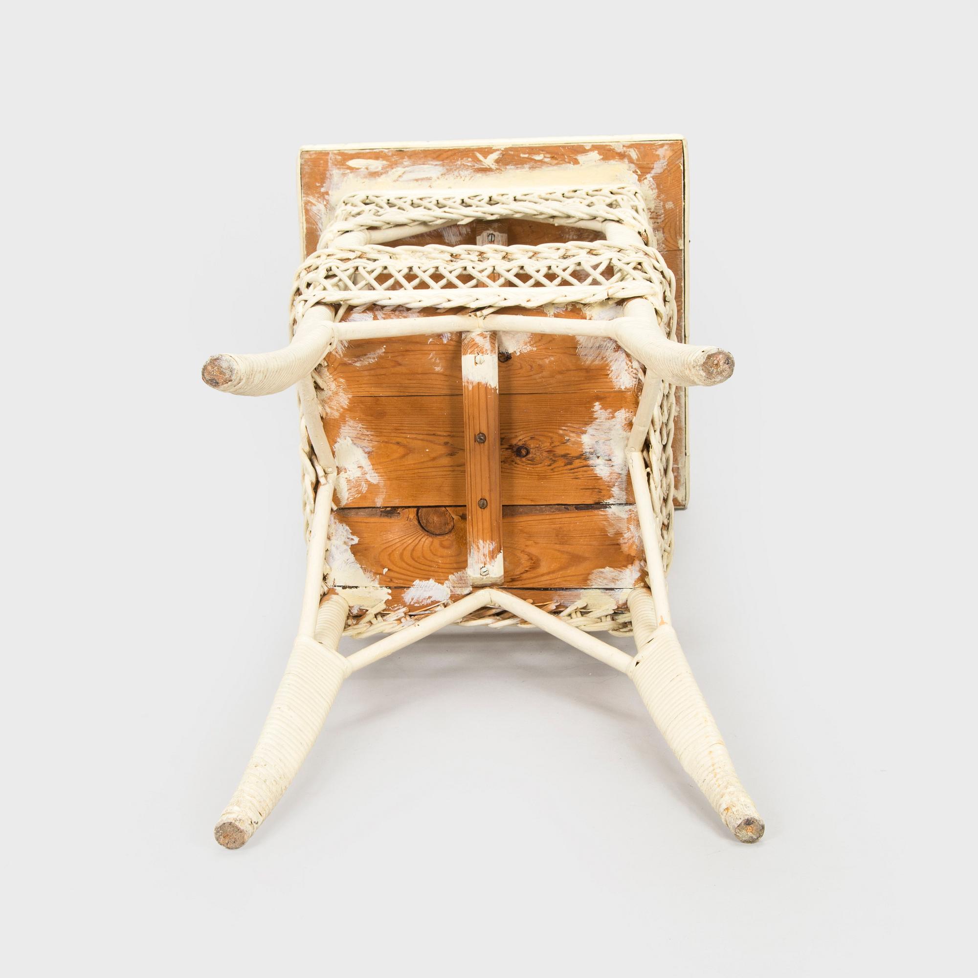A mid-20th-century three-piece rattan furniture set including two armchairs, and a table.