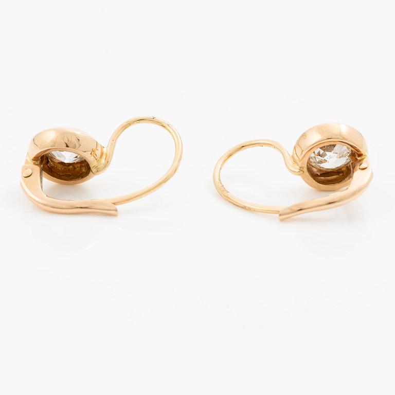 A pair of earrings in 18K gold set with two old-cut diamonds.
