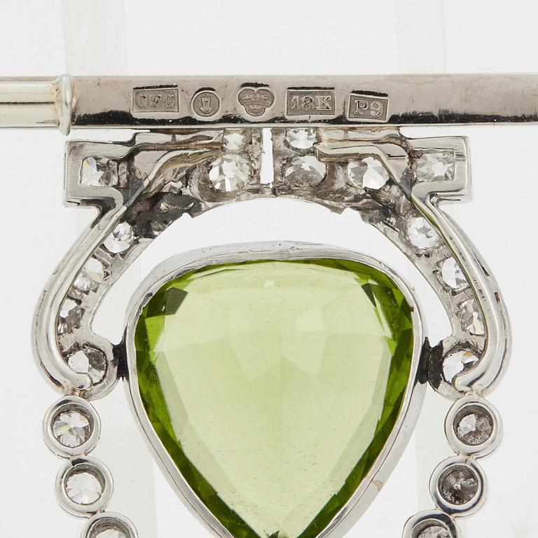 BROSCH med en droppformad fasettslipad peridot samt gammalslipade diamanter.