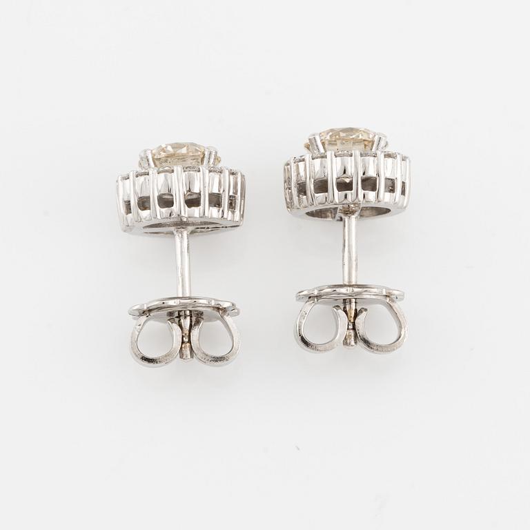 A pair of 18K gold earrings with round brilliant-cut diamonds.