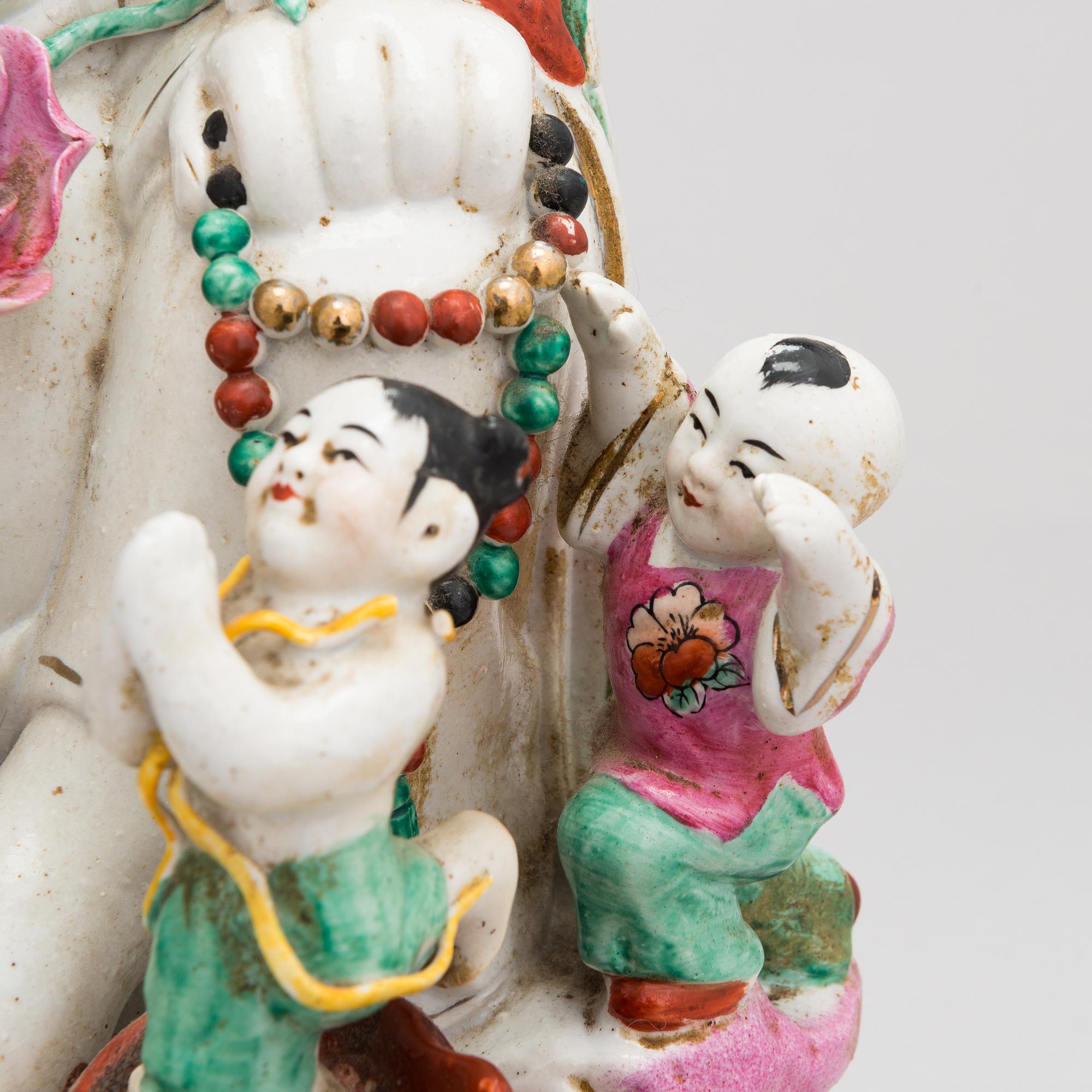 A Chinese porcelain laughing buddha with children, the 20th century.