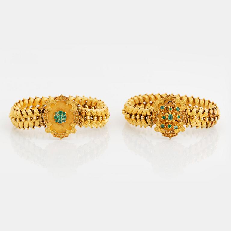 A bracelet/necklace combination in 14K gold set with faceted emeralds.