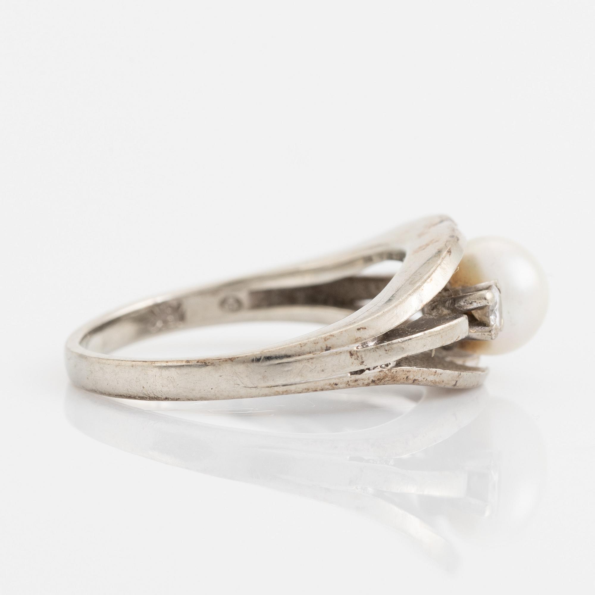 Ring med pärla och två briljantslipade diamanter.