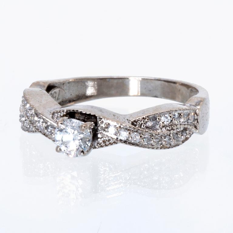 Ring 18K vitguld med 1 briljant ca 0,30 ct och briljanter ca 0,15 ct totalt.