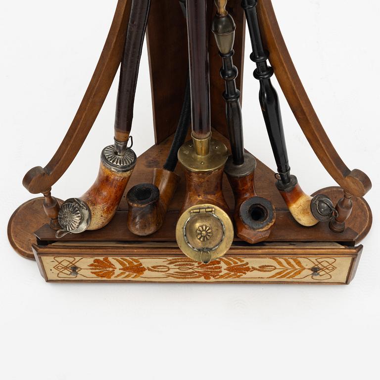 A pipestand and four pipes, circa 1900.