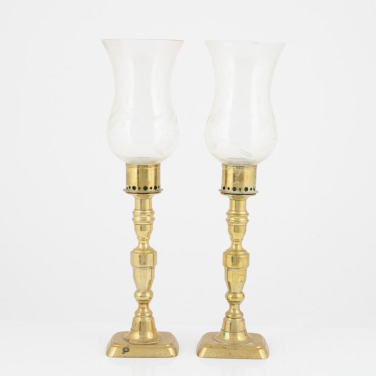 A pair of brass candlesticks with storm glass, 19th century.