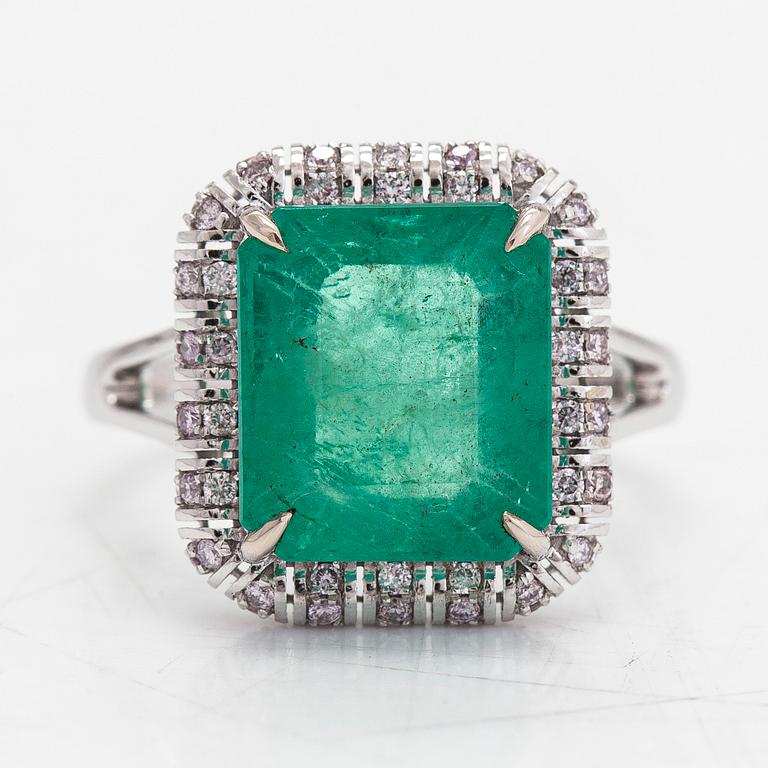 A 14K white gold ring, with an emerald approx. 5.21 ct and diamonds totalling approx. 0.23 ct, according to certificate.
