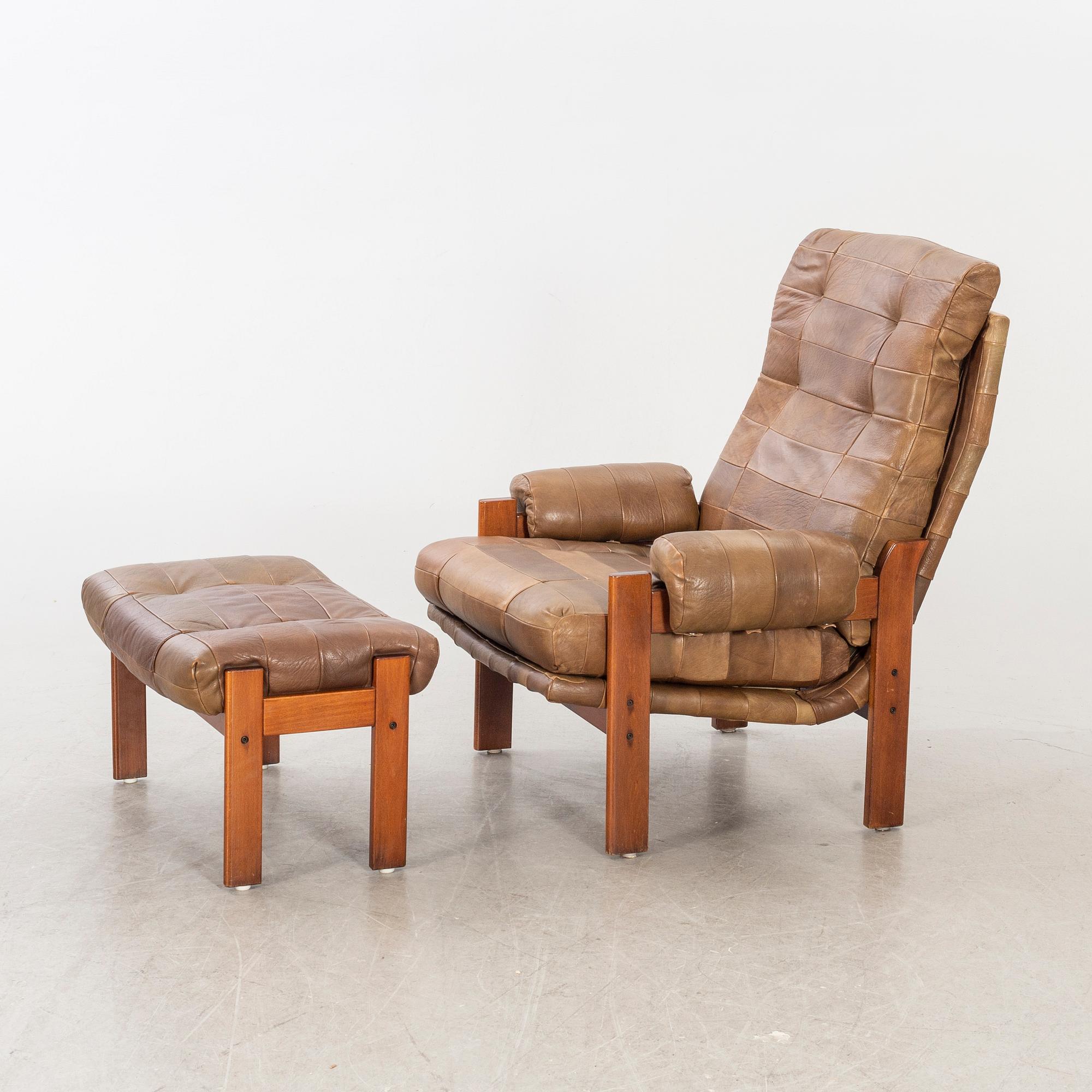 A pair of 1970/80:s easy chairs with stools.