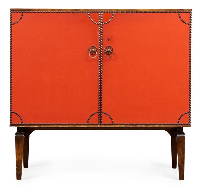 An Otto Schulz cabinet on stand with artificial red leather and brass details on a stained oak and birch stand, by Boet, Gothenburg, probably 1950's.