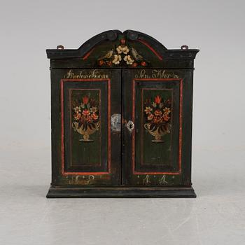 A hanging folk art wall cabinet southern Sweden dated 1844.