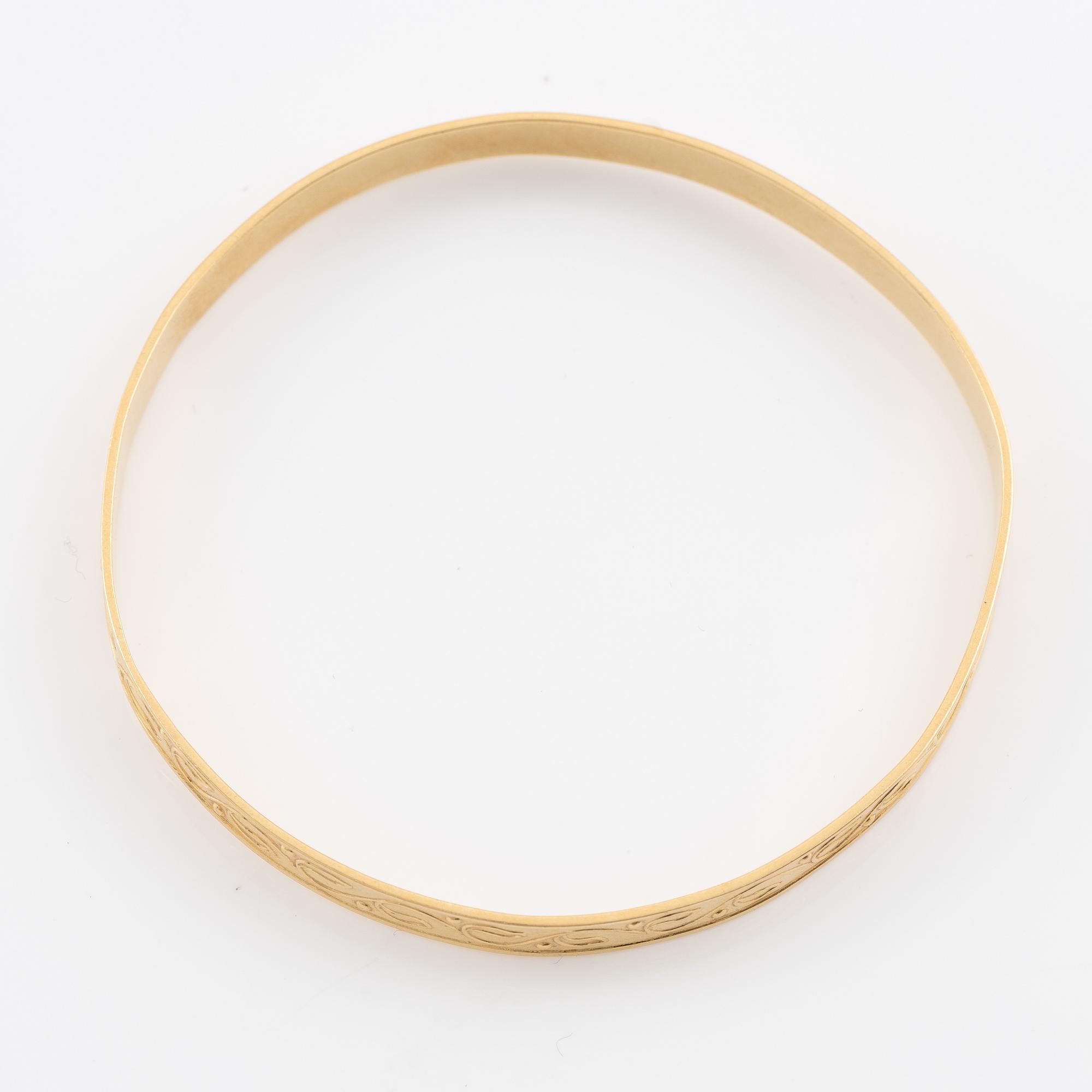 Arm ring, 18K gold with stylised decoration.