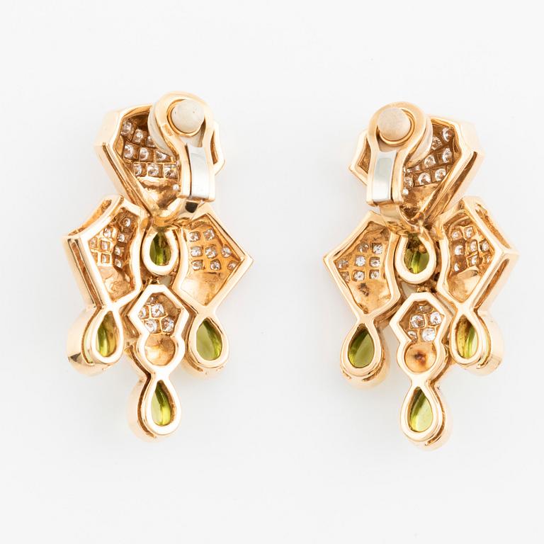 A pair of cabochon cut peridot and round brilliant cut diamond earrings.