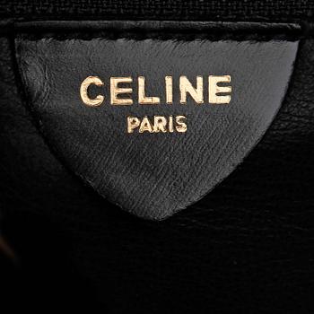 CÉLINE, a black and white leather clutch.