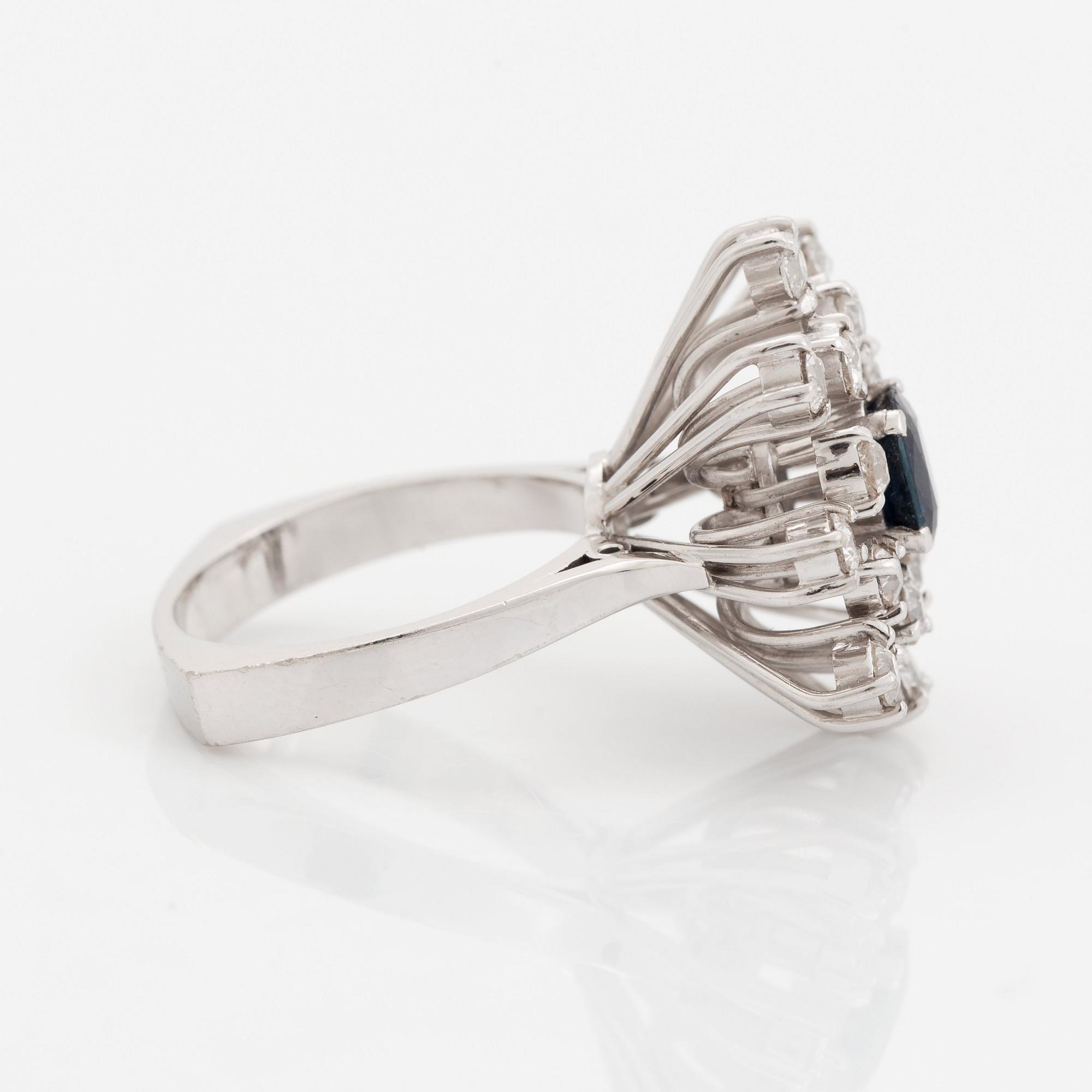 An 18K white gold ring set with a faceted sapphire and old-cut diamonds.