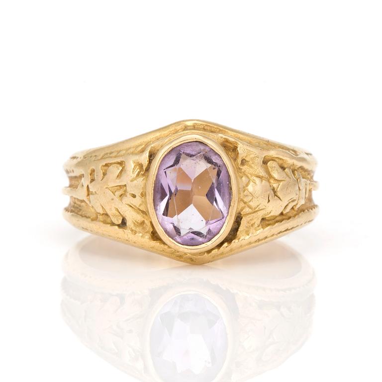 A ring with oval, mixed-cut amethyst.