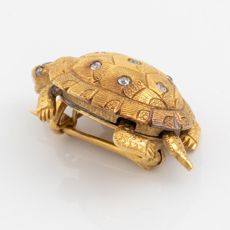 A brooch in the shape of a turtle.