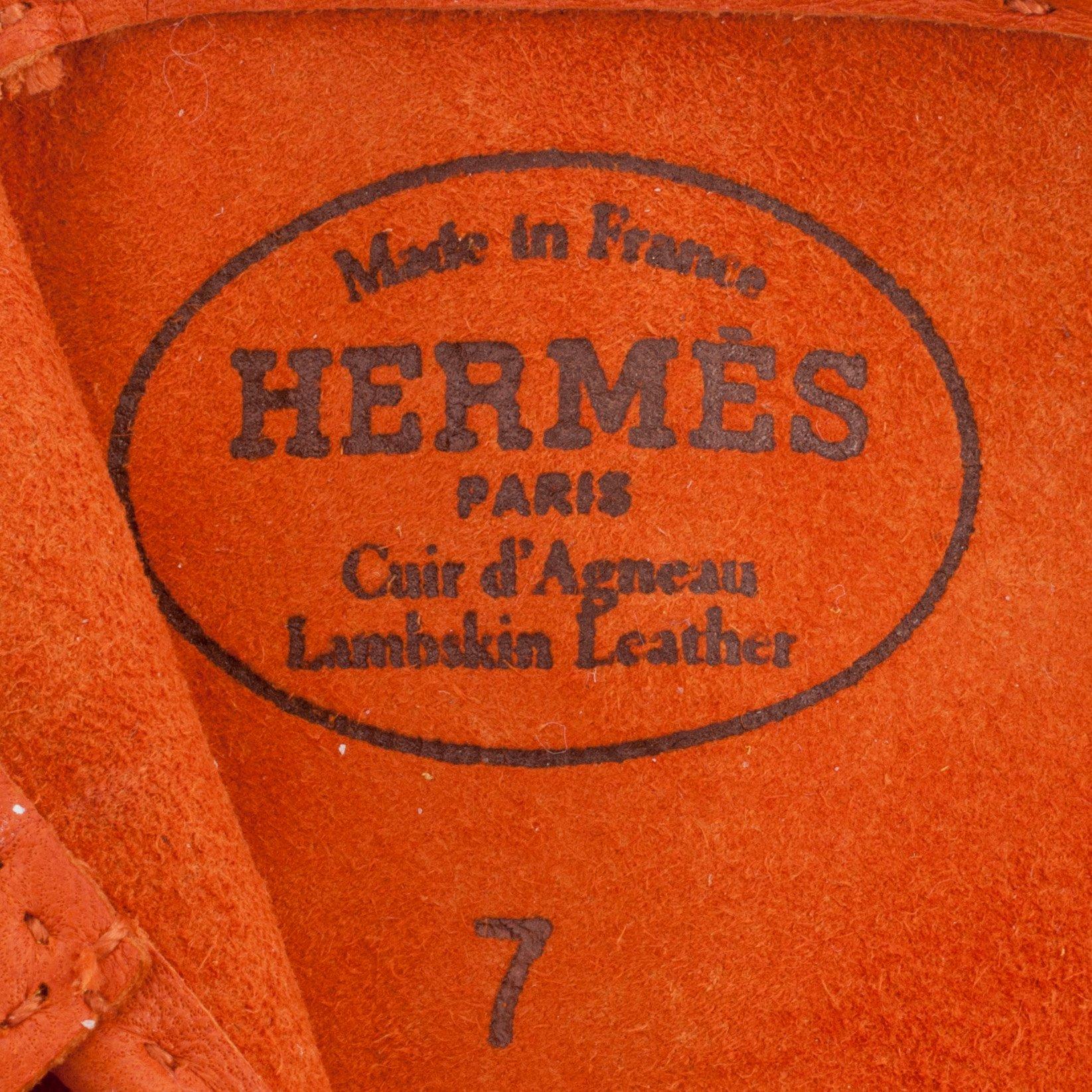 HERMÈS, a pair of orange lambskin leather gloves.